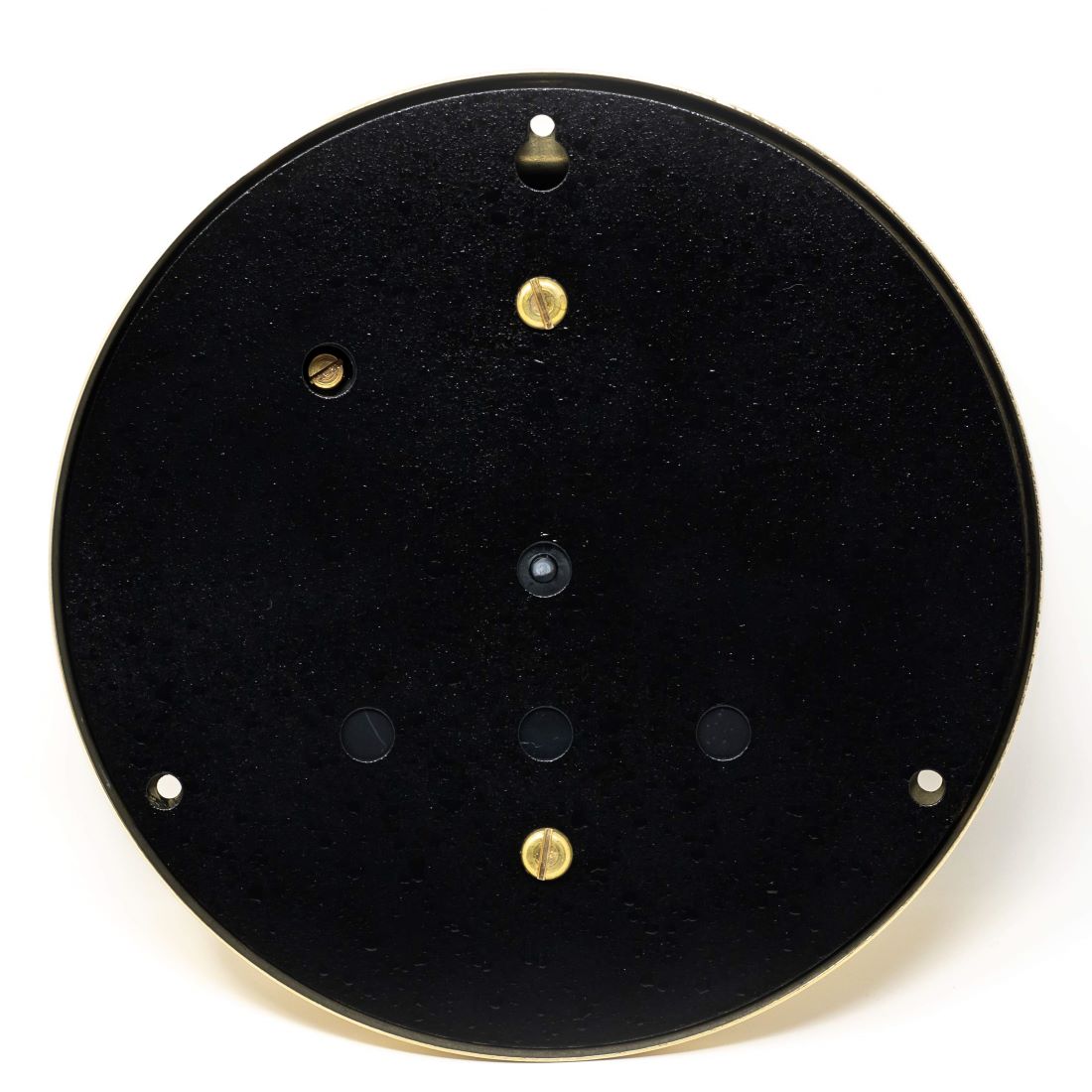 Back view of a round black barometer or clock case with gold screws and wall mounting holes