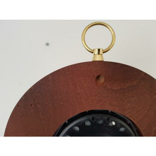 Close-up of a wooden barometer or clock back with brass hanging ring, German weather instrument