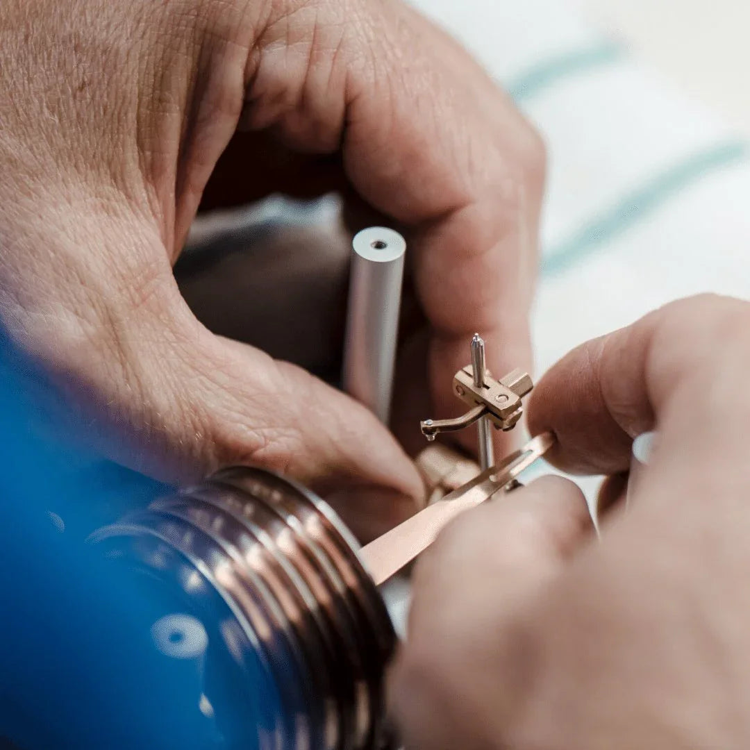 Close-up of hands assembling a precision barometer mechanism, German instrument craftsmanship