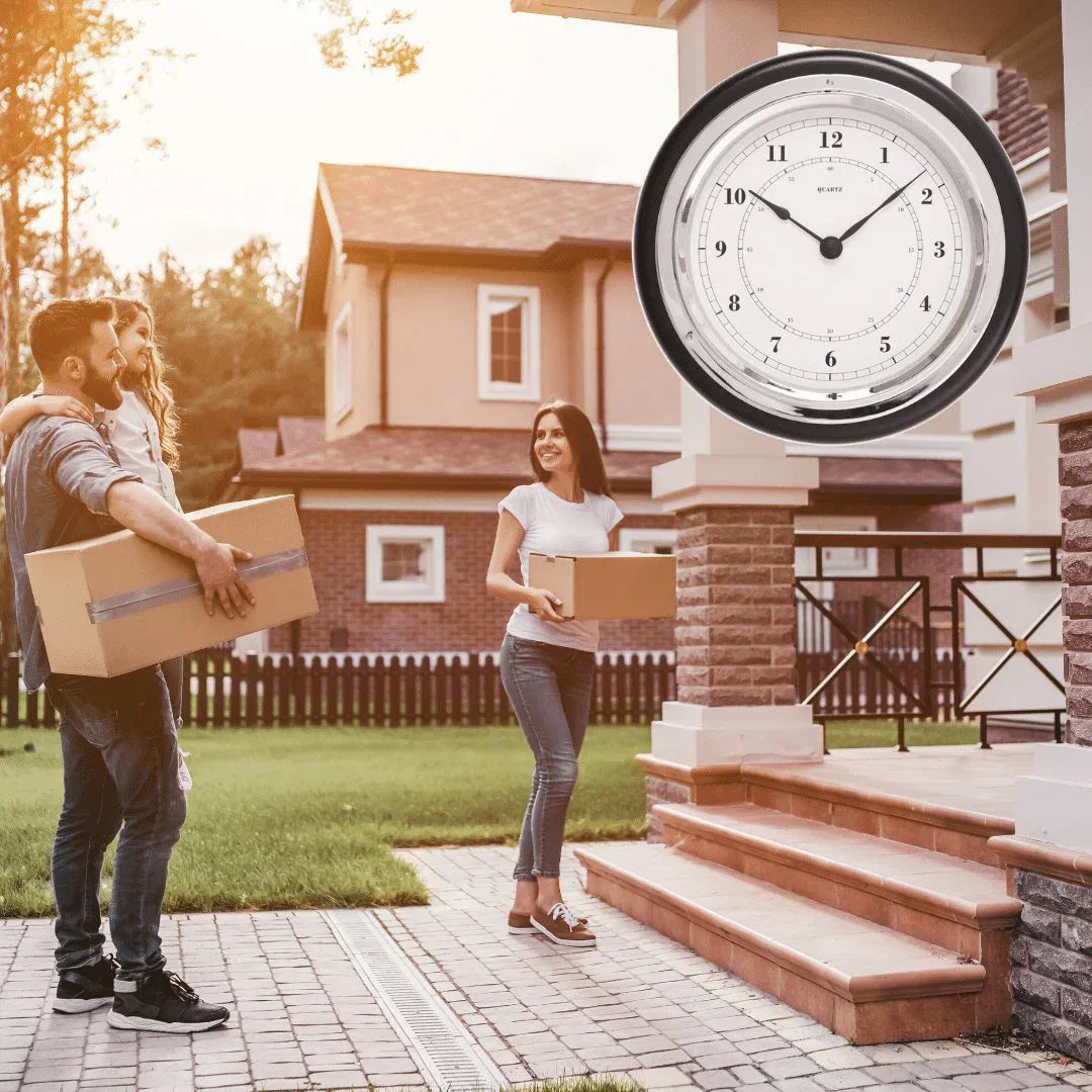 Large wall clock displayed outside a modern house with family carrying moving boxes