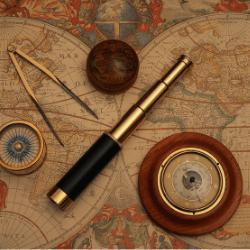 Vintage nautical barometer, compass, and telescope on an old world map