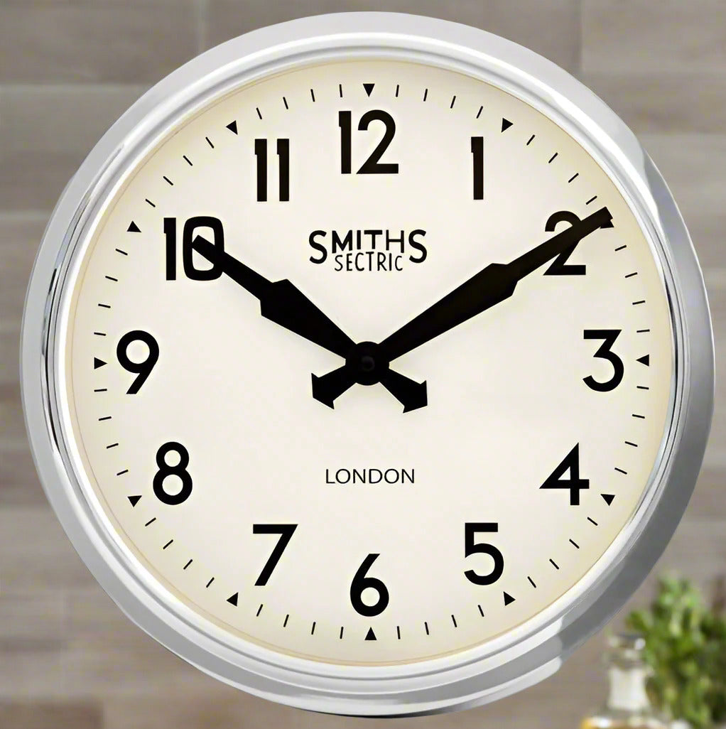 Classic wall clock with white face, black numbers and hands, chrome frame, indoor setting